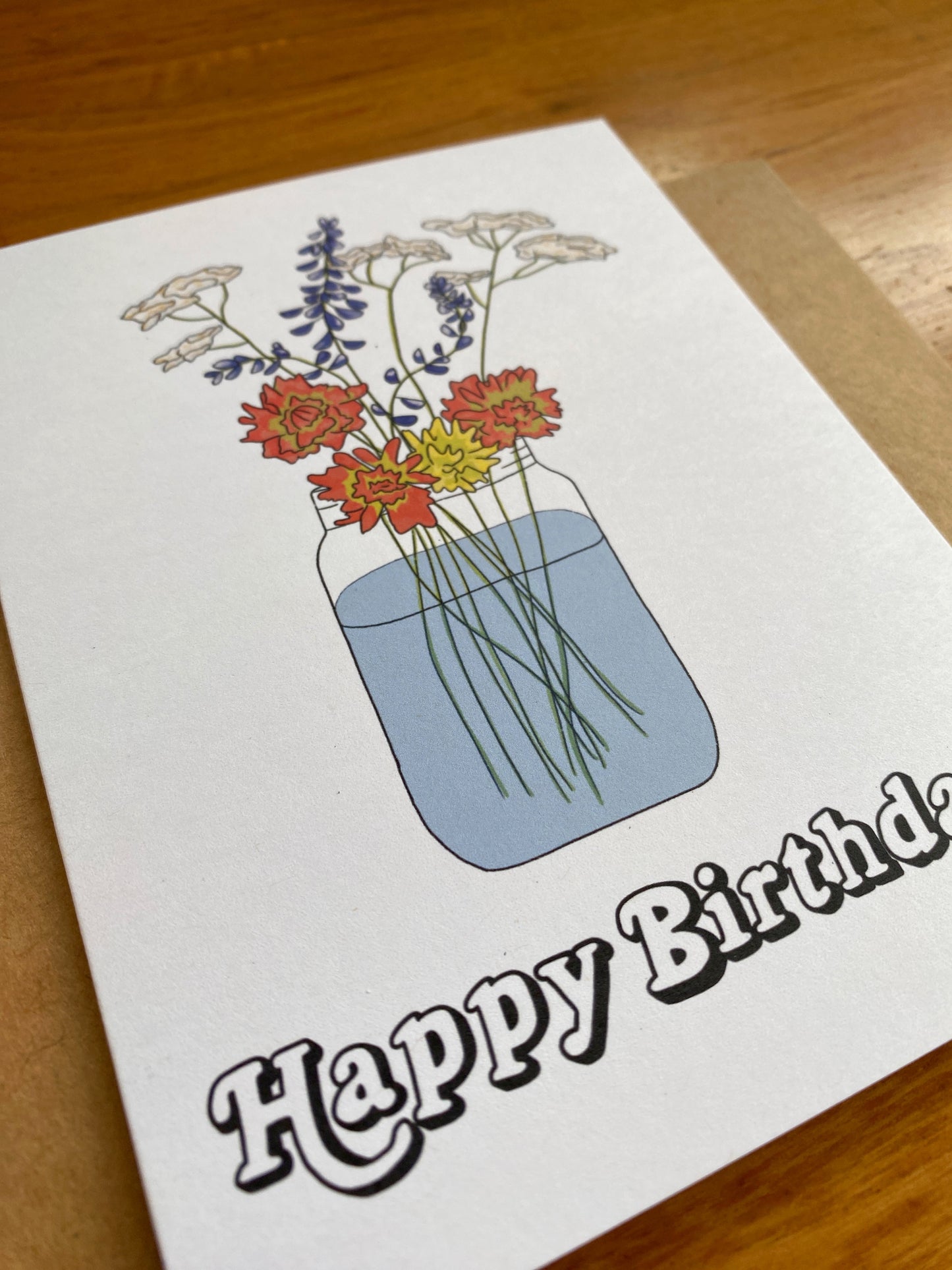 Greeting card with Wildflower bouquet in a mason jar with "Happy Birthday" written underneath.