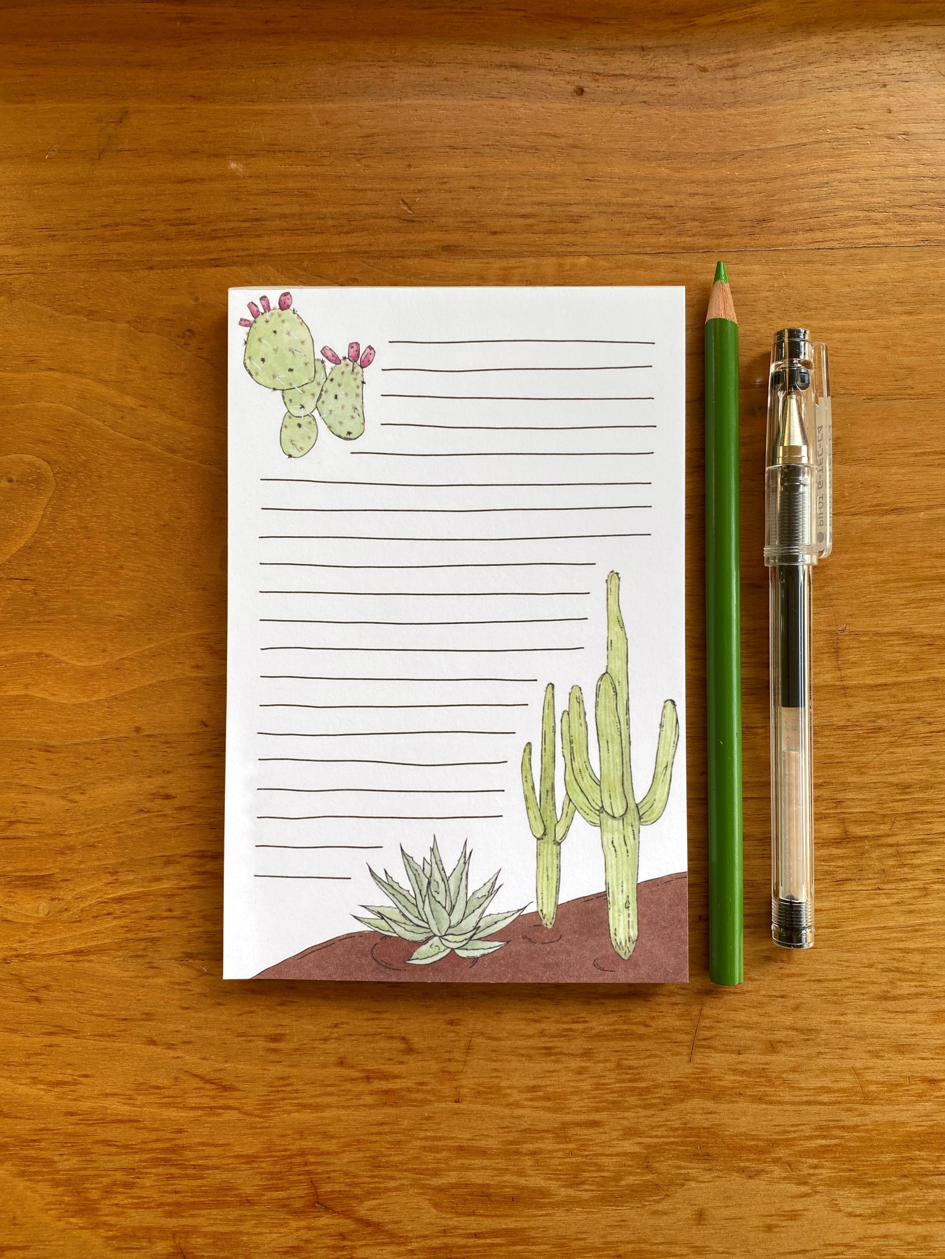 Lined notepad with cactus watercolor paintings.