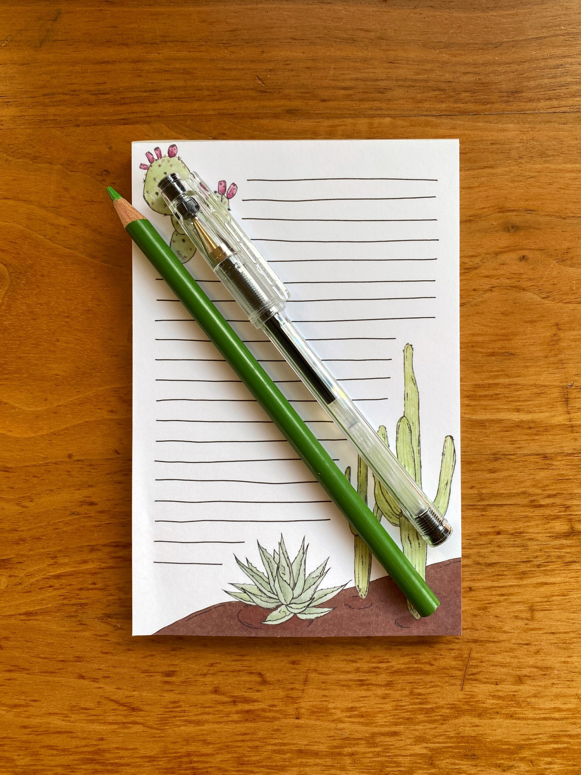 Lined notepad with cactus watercolor paintings.