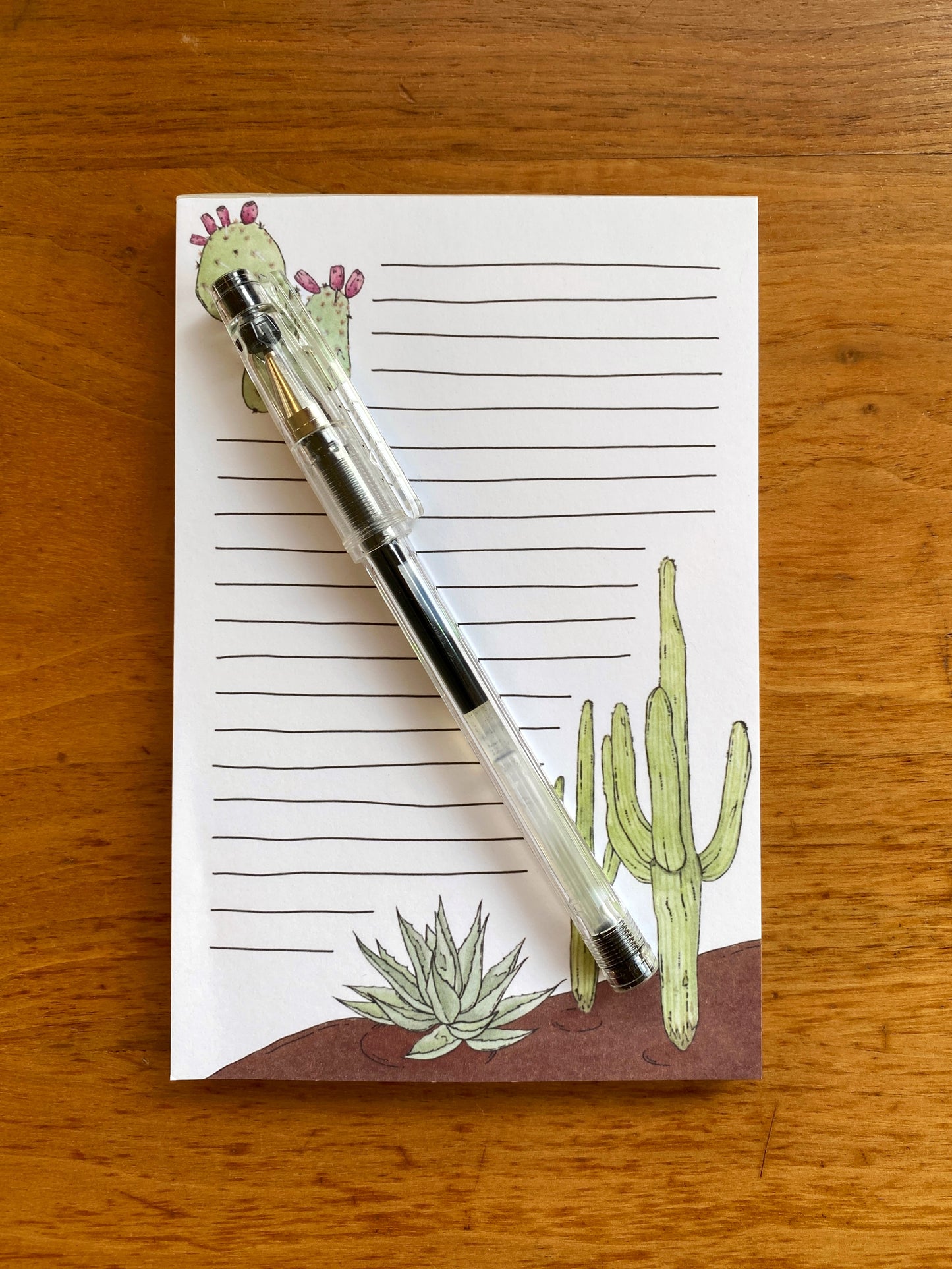 Lined notepad with cactus watercolor paintings.