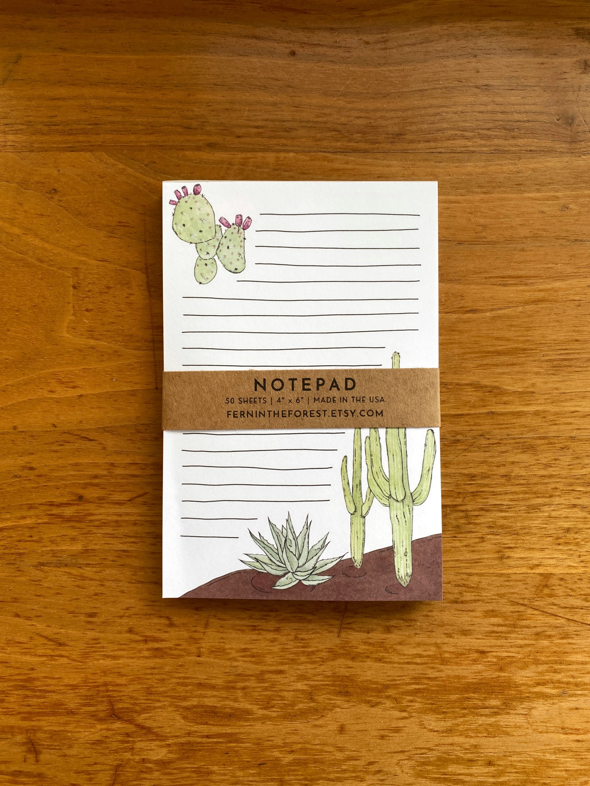 Lined notepad with cactus watercolor paintings.