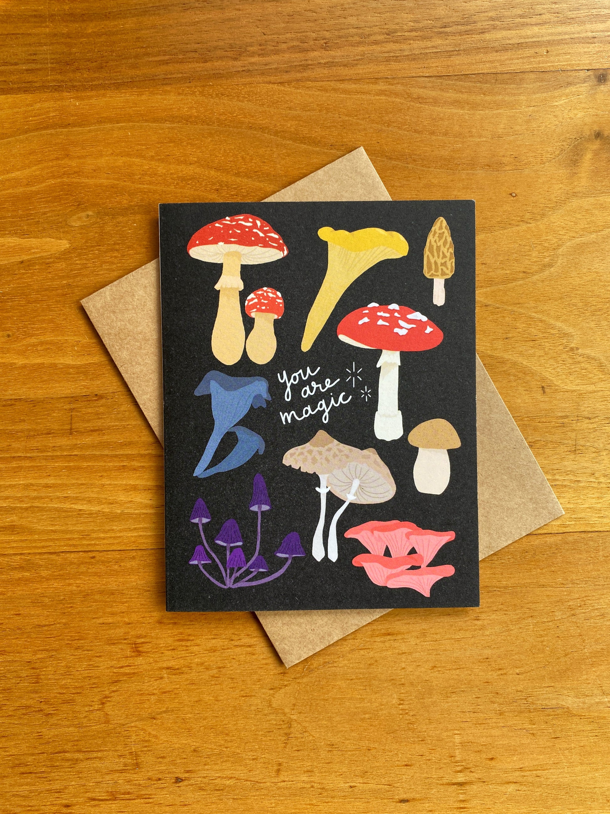 greeting card with black background, multiple mushrooms and says "You are magic"