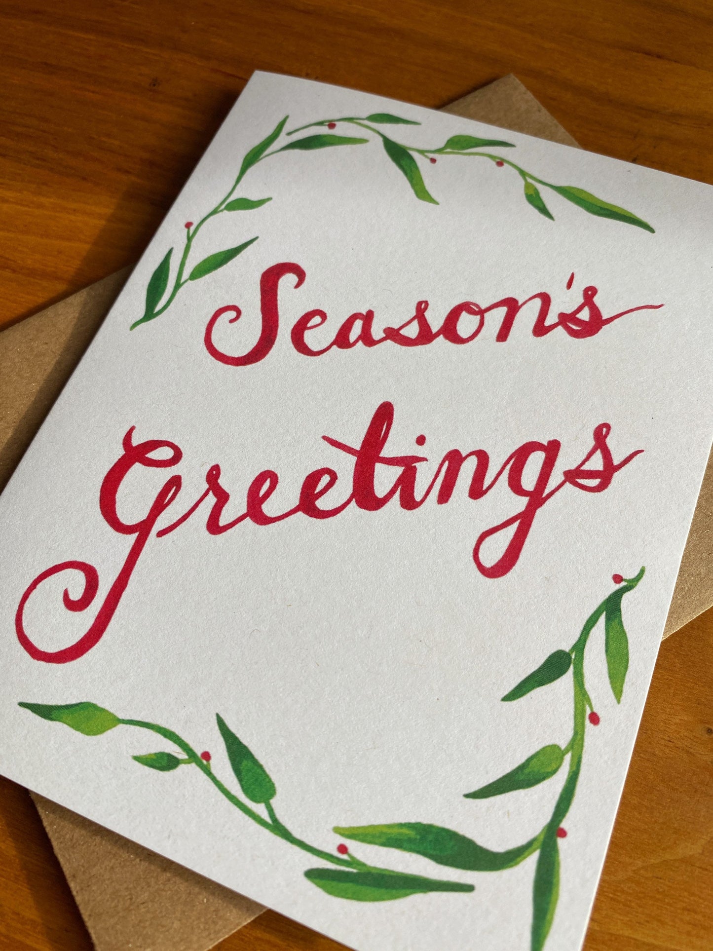 Greeting card with watercolor greenery and "Season's Greetings"