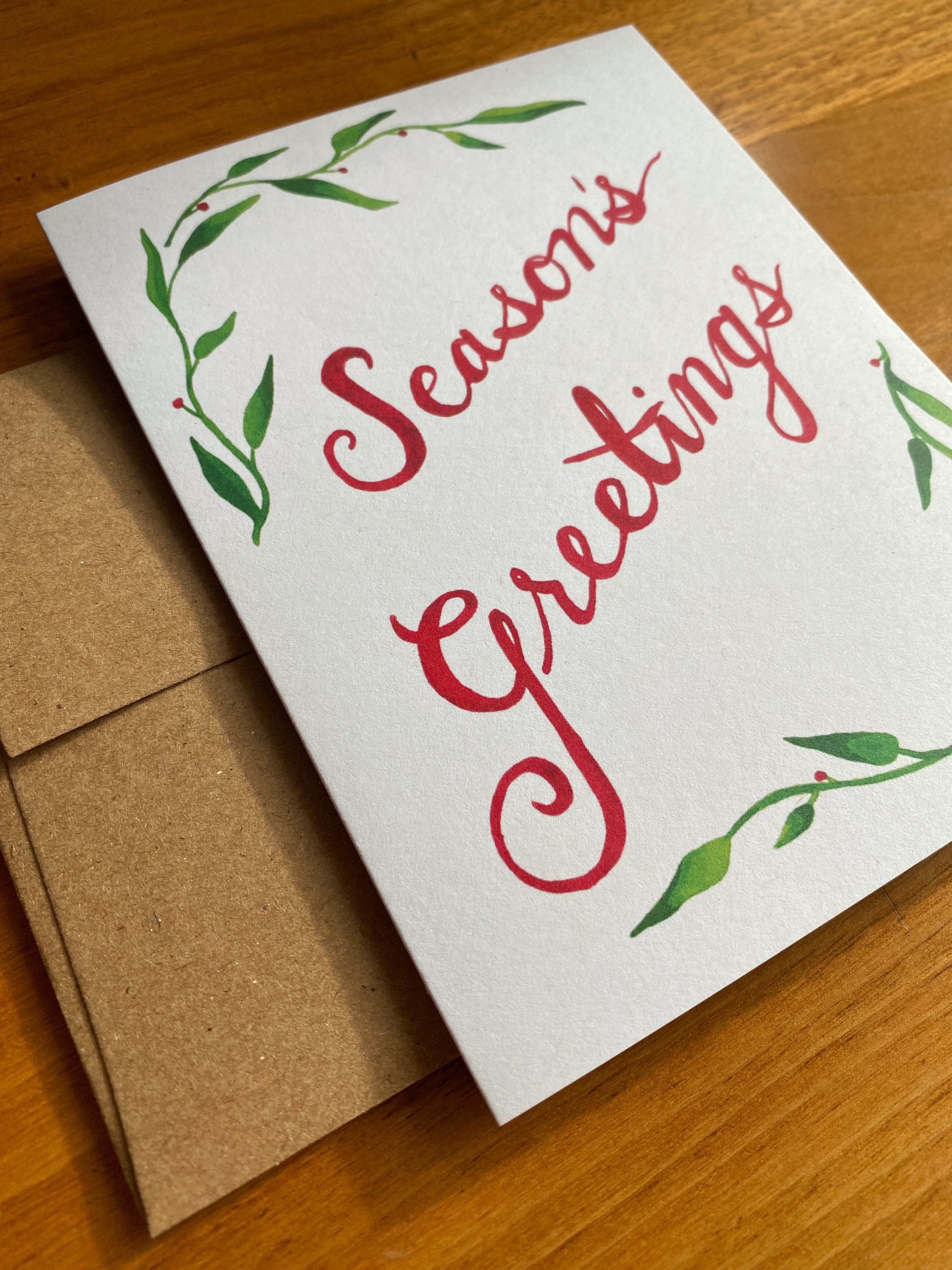 Greeting card with watercolor greenery and "Season's Greetings"