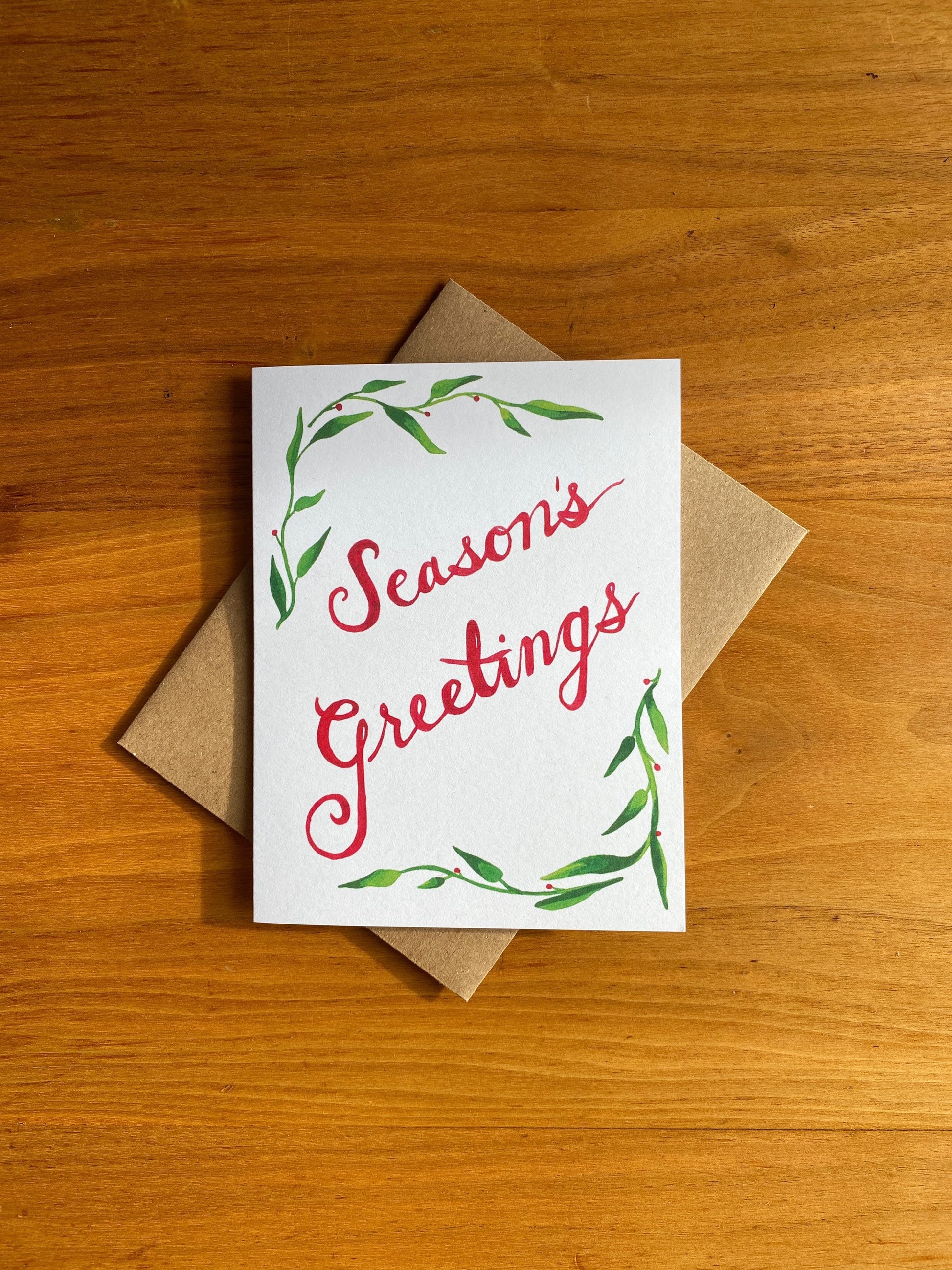 Greeting card with watercolor greenery and "Season's Greetings"